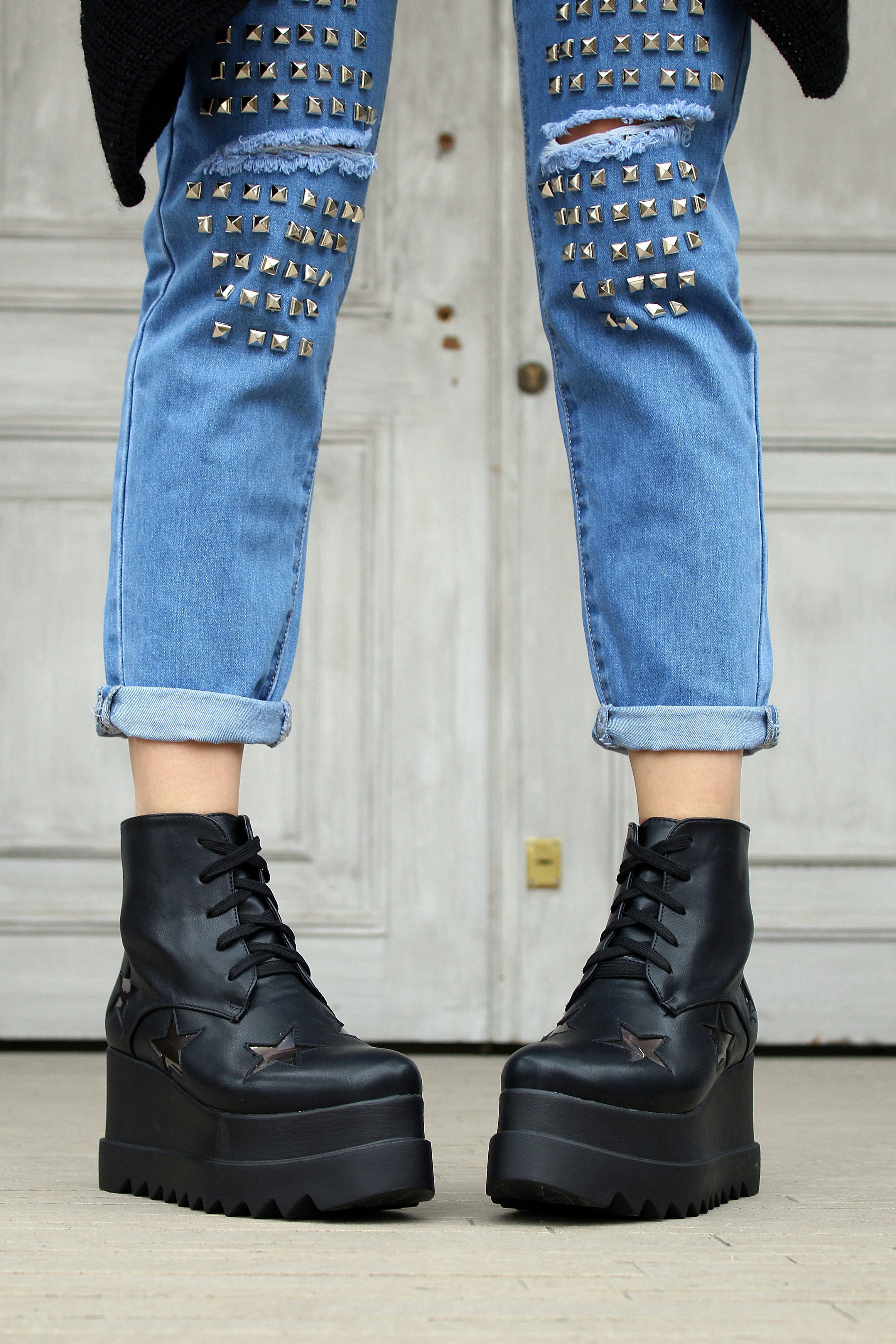 person in blue denim distressed jeans and black platform boots